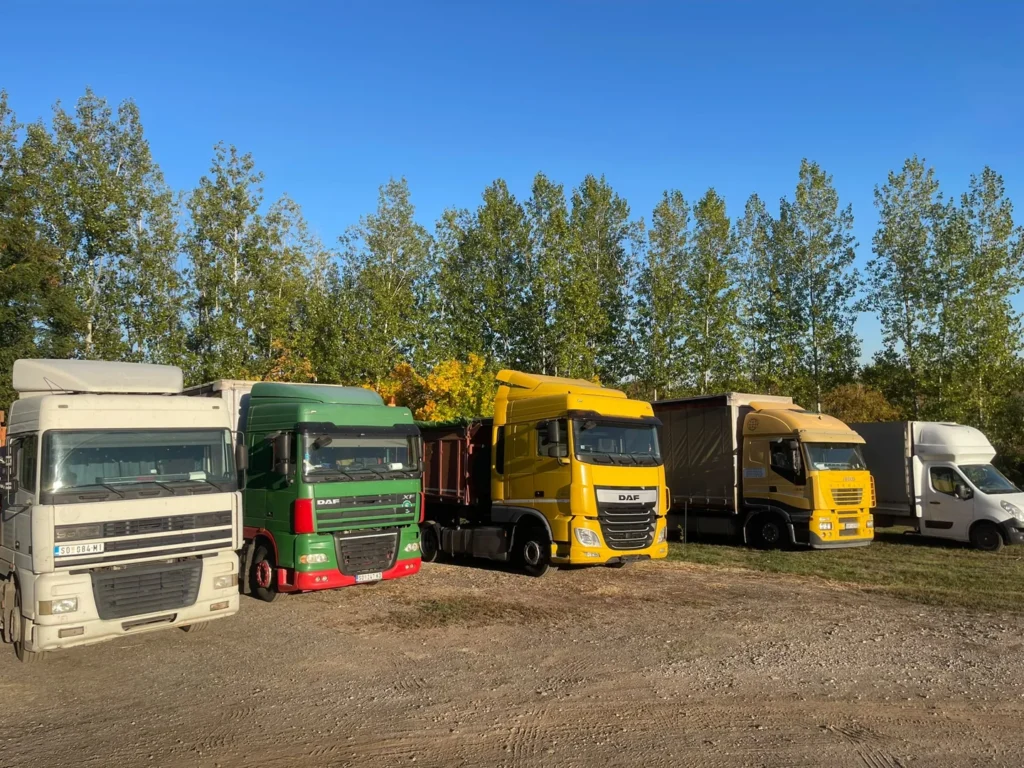 Kamioni i manje transportno vozilo u dvorištu u Somboru.